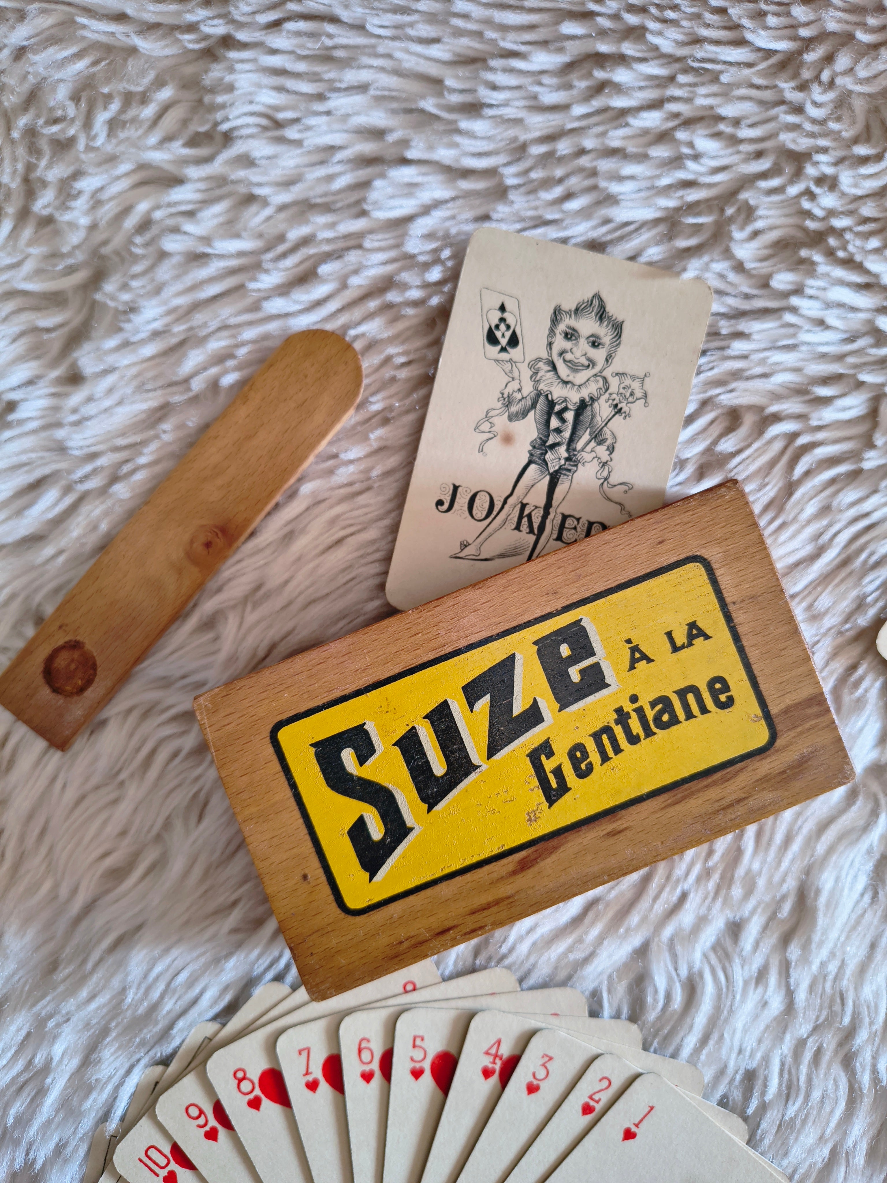 Jeu de 54 cartes à jouer et leur boitier en bois Suze détail Joker